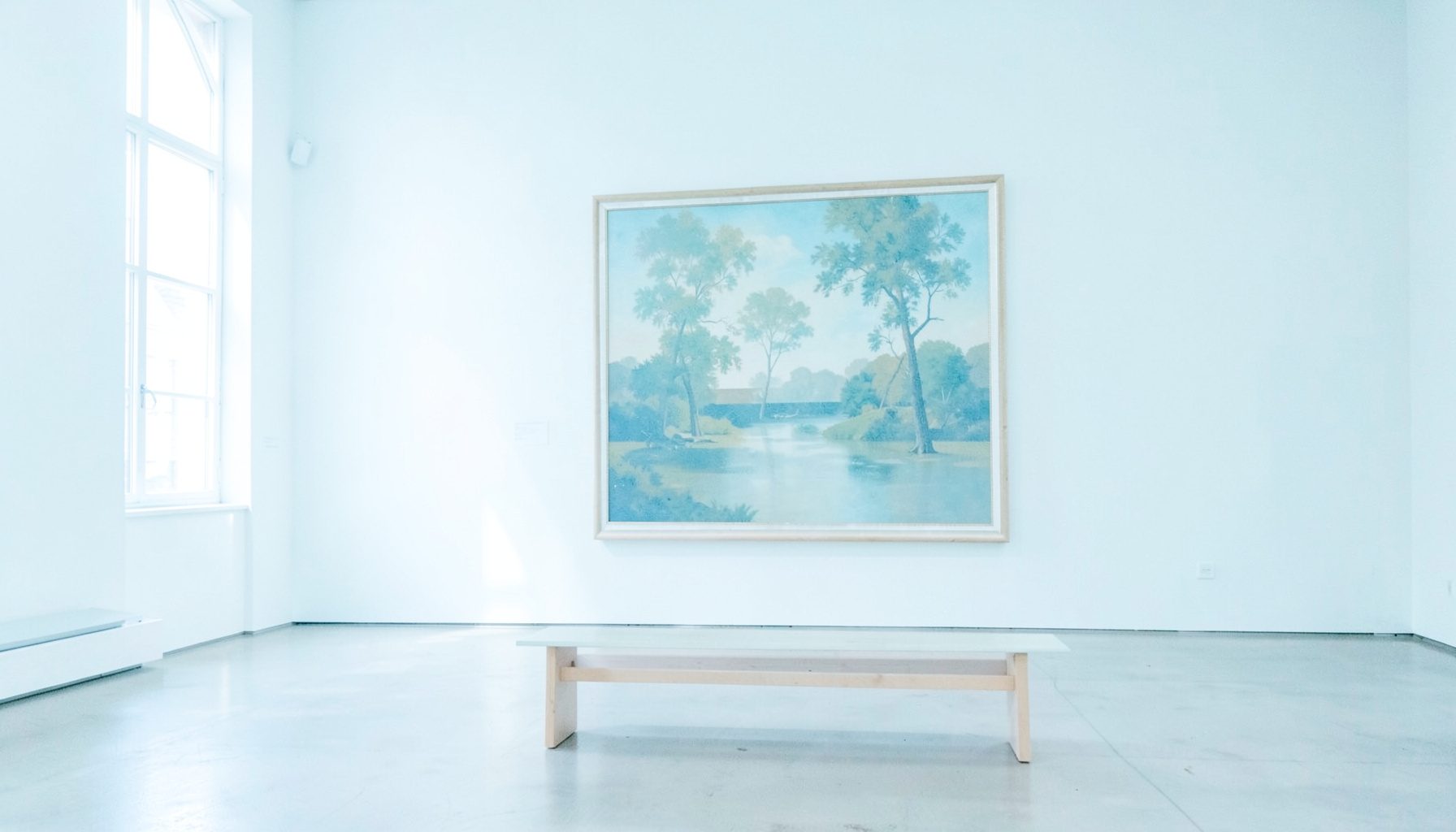 A sunlit museum gallery with a large framed painting on a pale wall, empty bench in the foreground